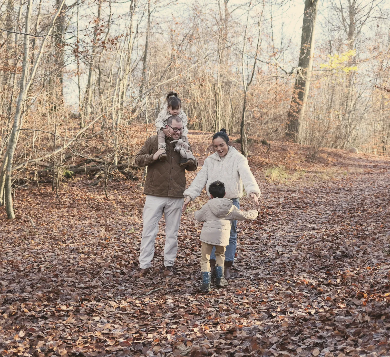 Eine Familie spaziert durch einen herbstlichen Wald